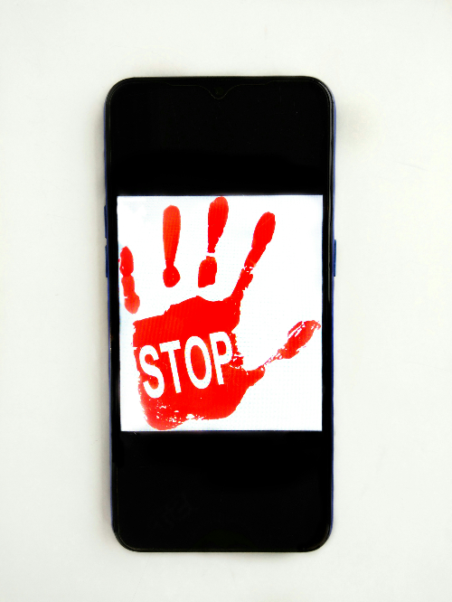 빨간색 STOP 단어가 쓰여있는 핸드폰 화면. 출처 : Unsplash
