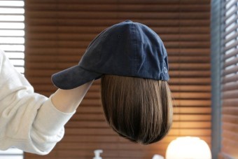 진한-청색의-항암모자가발을-들고있는-모습