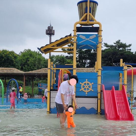 궁평항 물놀이터 사진. 꼭대기의 바구니에서 물도 쏟아져서 더욱 신난다. 물이 깊지 않아서 아이들이 안전하게 놀기 좋다.