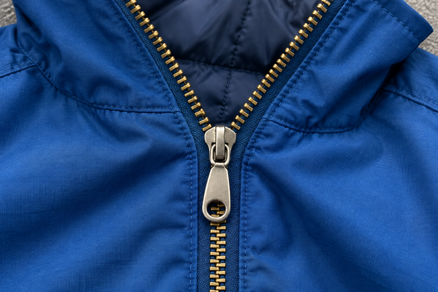 A partly closed jacket zipper with open edges above the slider and joined teeth below