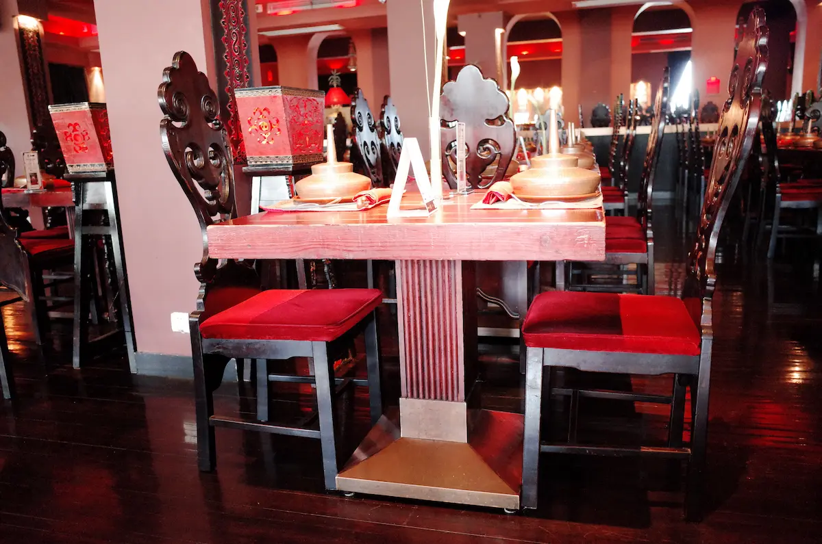 붉은 벨벳 의자와 묵직한 나무 테이블이 어우러진 상해 로스트 헤븐의 고급스러운 기본 테이블 세팅
