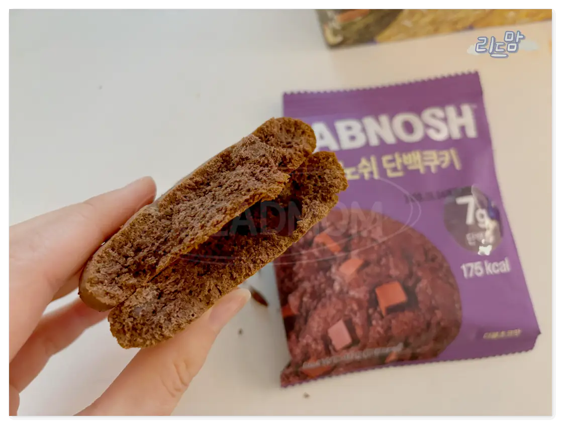 랩노쉬-단백질쿠키-더블초코-단면-손-보라색 포장지