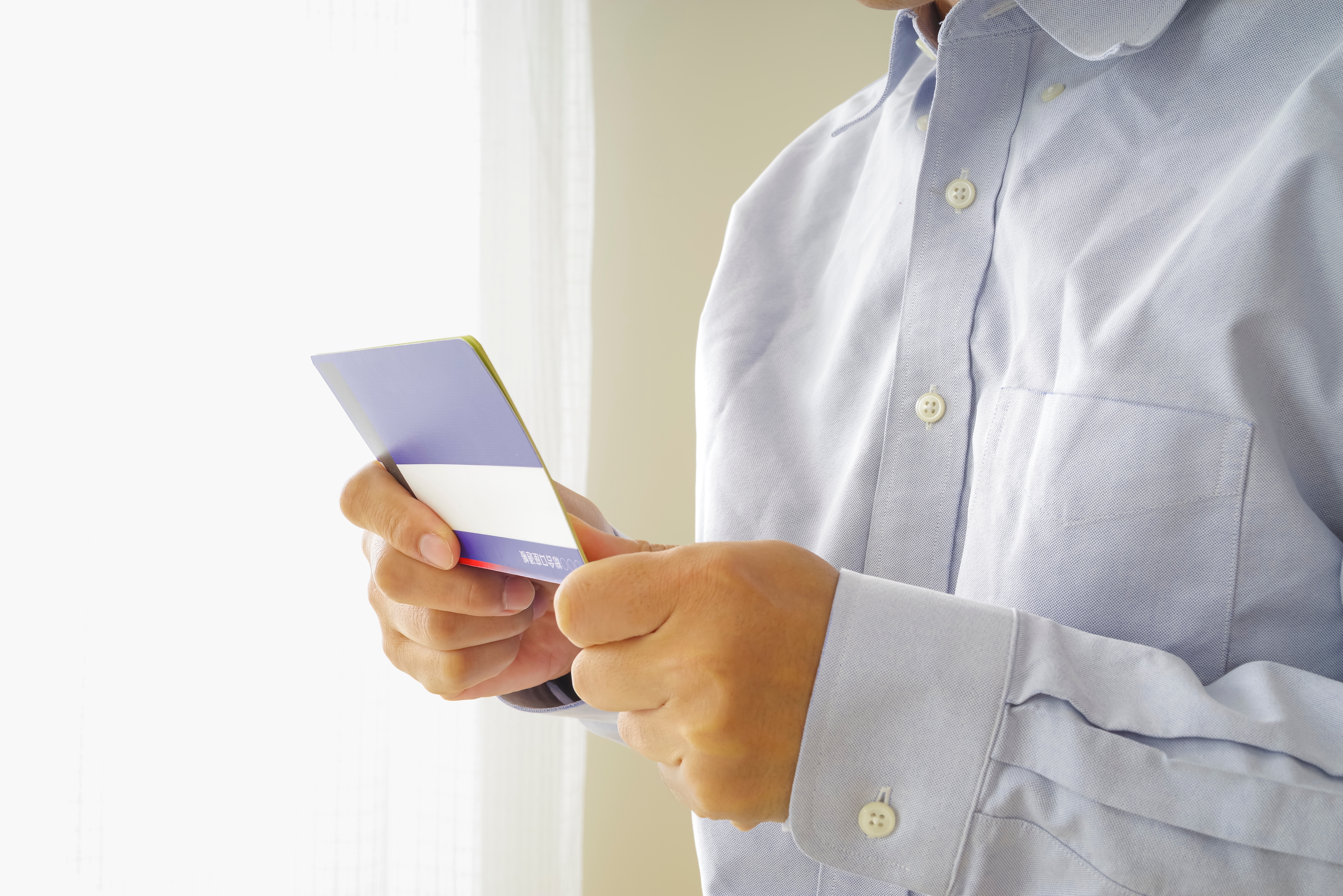 청년도약계좌를 확인 중인 남성의 모습, 통장을 들고 있는 장면