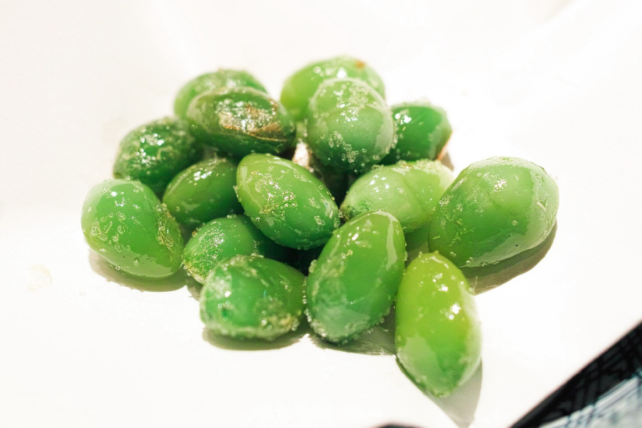 야생에서 채취를 한 은행 열매의 속 알맹이를 잘 볶아서 만든 은행구이를 흰색 접시 위에 여러 개 놓아두고 찍은 사진