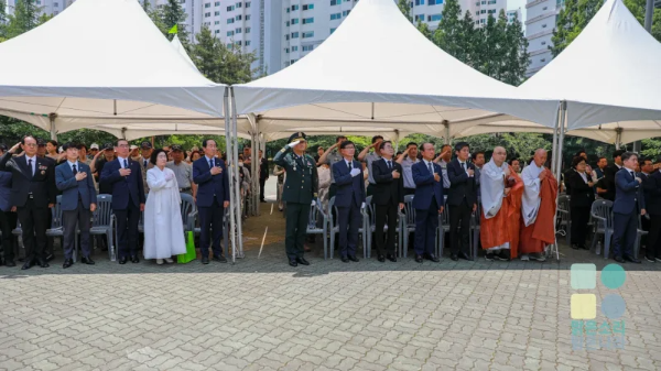 위령재에서 내빈들이 국기에 대한 경례를 하고 있다