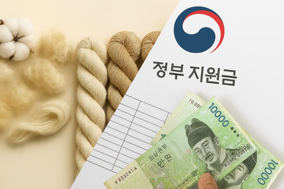 섬유 소재와 정부 지원금 서류, 한국 지폐가 함께 배치된