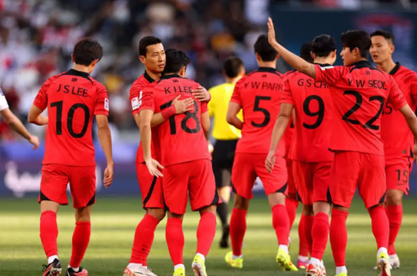 태국전- 축구그라운드 위 붉은 유니폼을 입은 축구선수들이 손을 흔들며 퇴장하는 뒷모습
