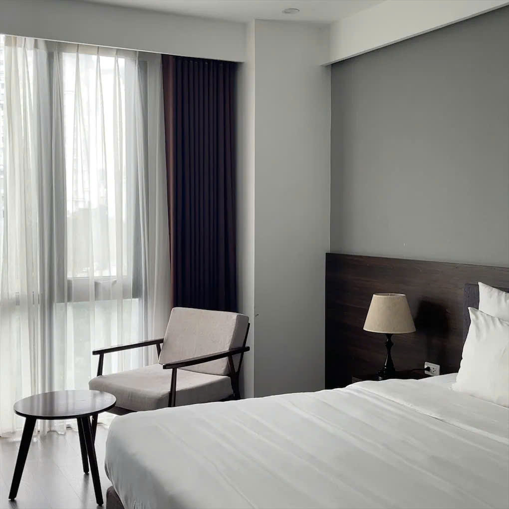 REYNA Hotel 객실 내부 모습 - 테이블과 침대