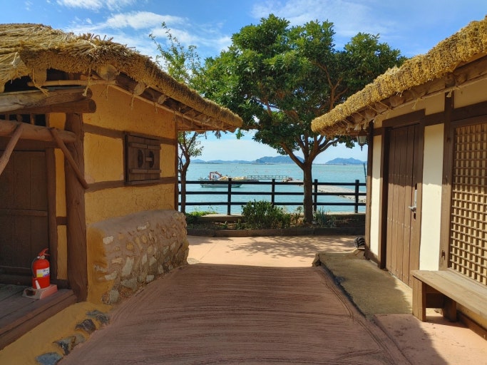 완도 청해포구 세트장의 전통 초가 마을 풍경과 산자락 배경