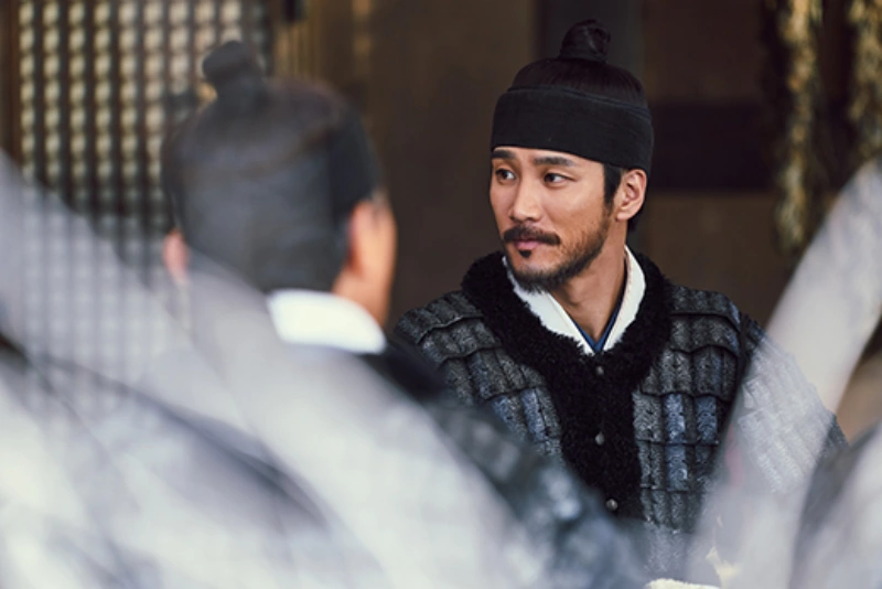 조선 군관 복색을 하고 앉아 있는 이회 역의 배우 안보현