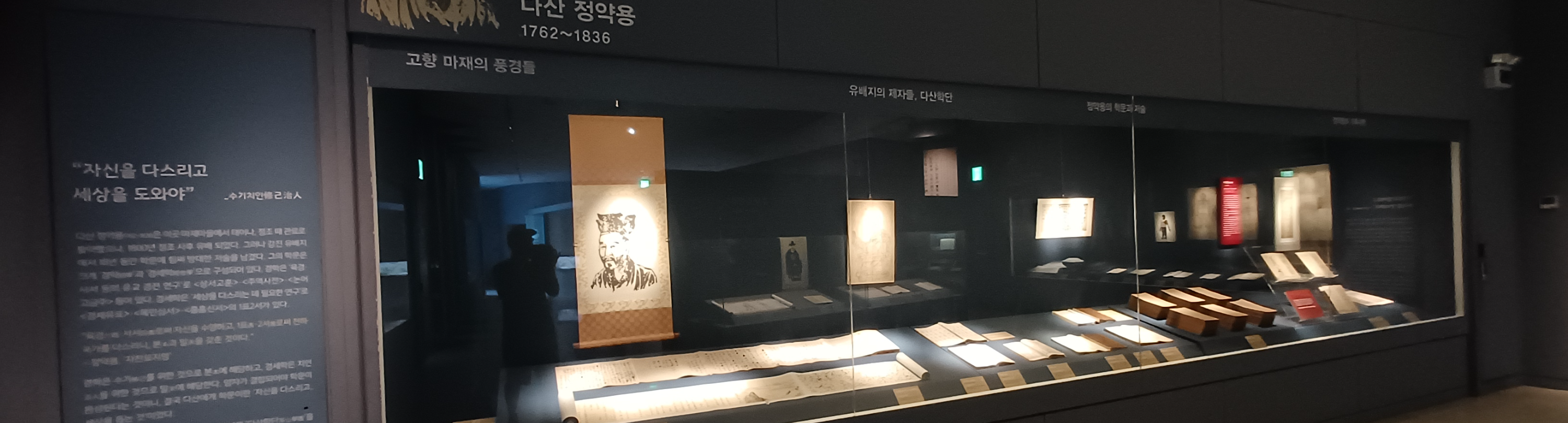 실학 박물관 내부- 조명이 비치는 유리 진열관 내부에 전시된 정약용의 초상화와 여러가지 도서들.