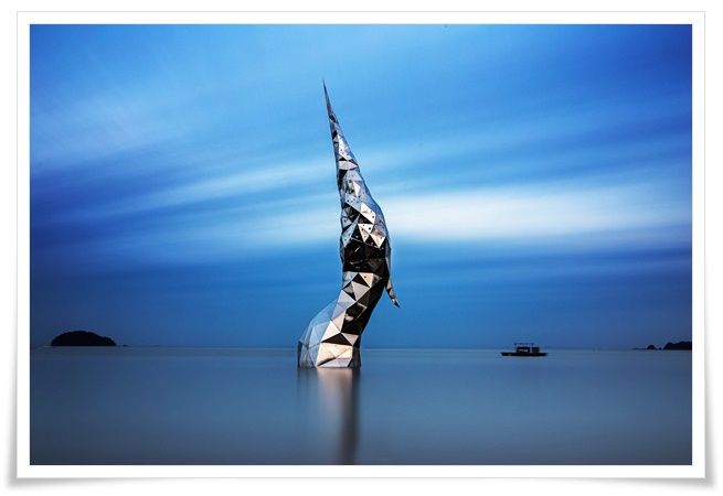 바닷물속에 잠겨있던 왜가리가 하늘로 솟아올라가는듯한 느낌의 조형물이 바다에서 하늘로 우뚝 서있는 멋있는 풍경