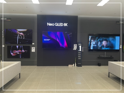 삼성스토어-용인시청점에-전시된-Neo-QLED-8K-TV.-고화질-화면으로-생생한-영상을-제공하며,-벽면-디스플레이와-쇼룸-분위기가-고급스러움을-강조.