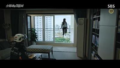 아파트 거실 창문 난간에 앉아있는 여고생