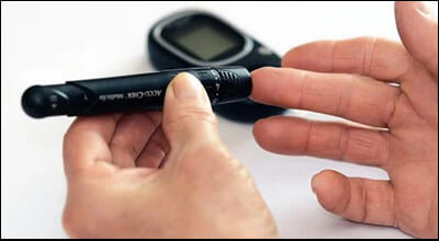 혈당체크를 하고 있는 손