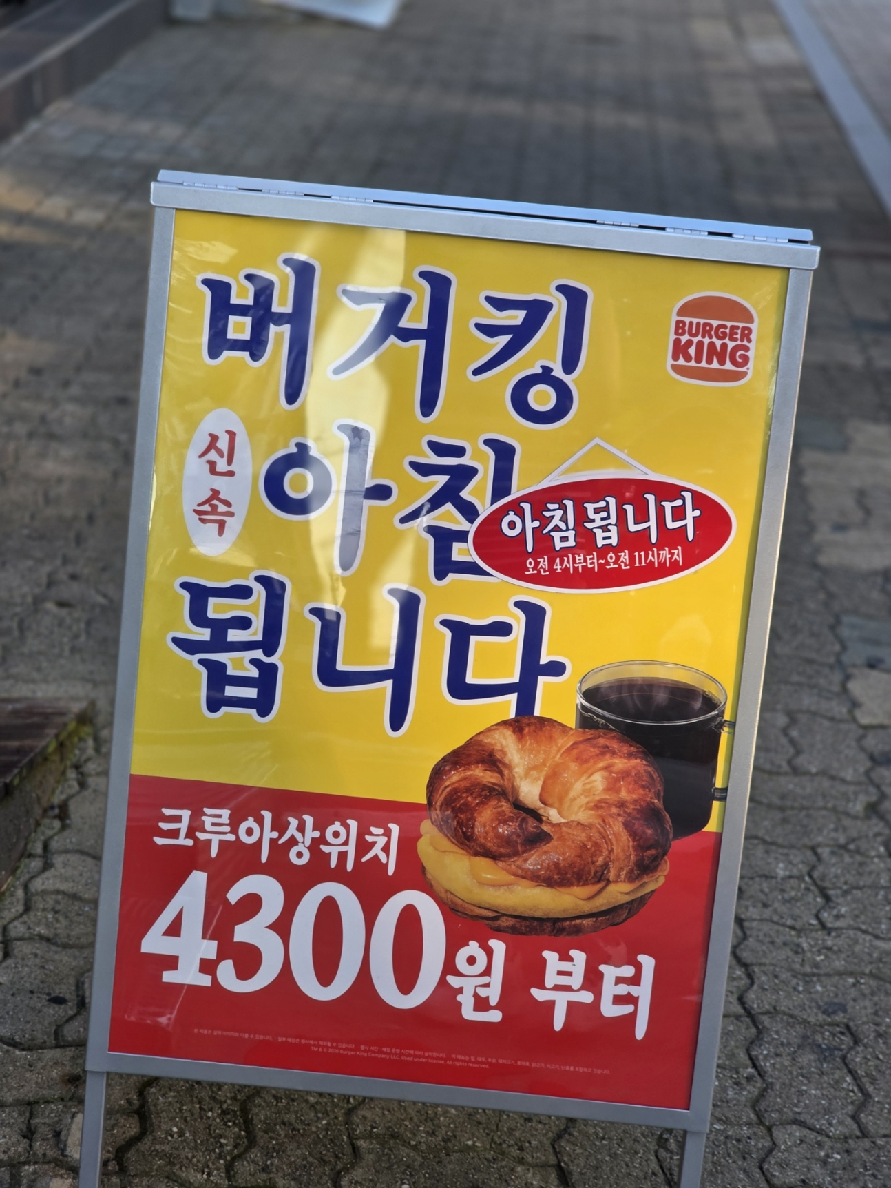 보도 옆 입간판에 노란색과 빨간색 바탕으로 &lsquo;버거킹 아침 됩니다&rsquo;와 크루아상위치 4,300원부터라는 문구가 표시된 모습