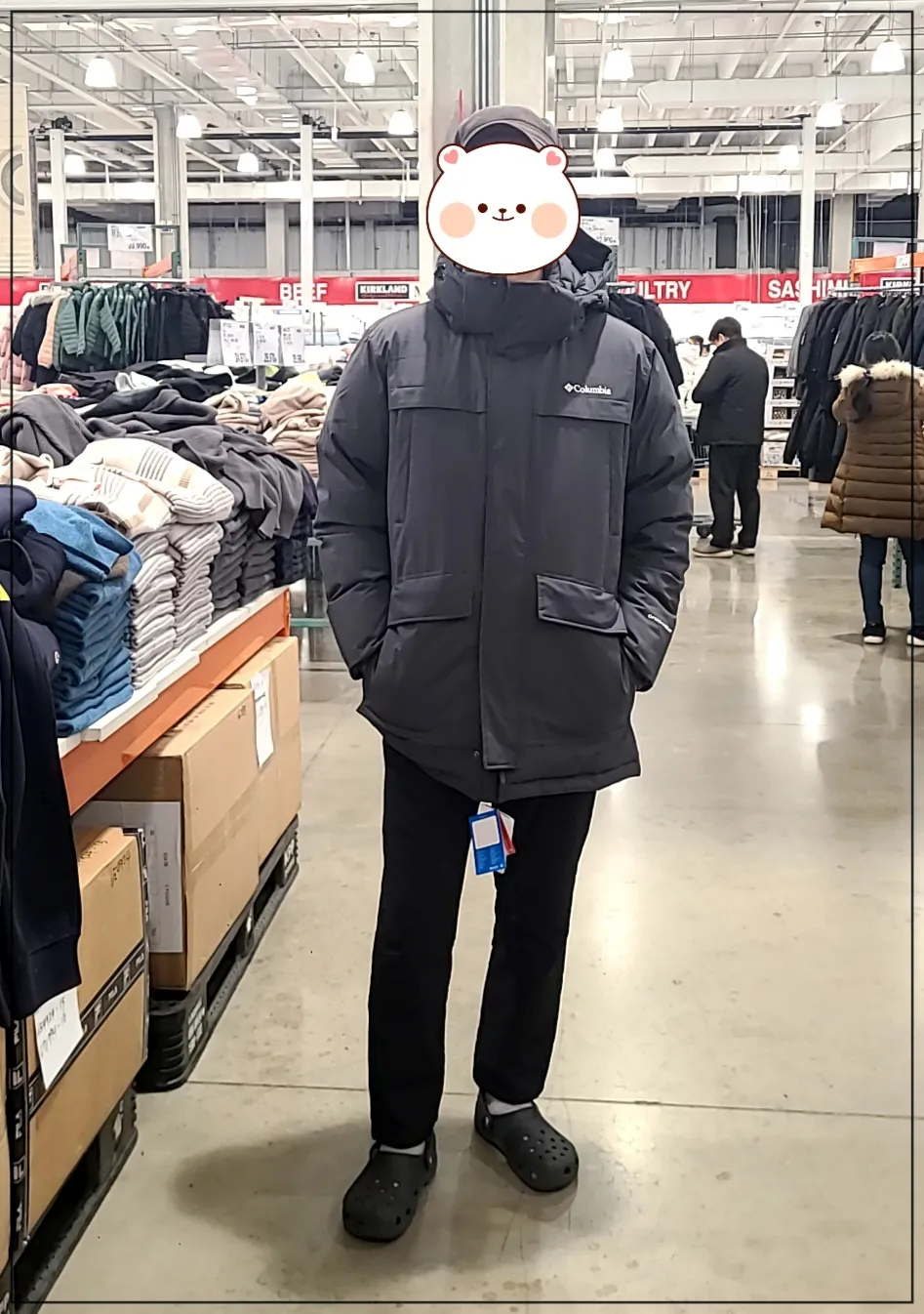 코스트코매장내부 진회색 콜롬비아 남성 헤비다운자켓과 검정모자를 쓴 남성이 서 있는 정면모습