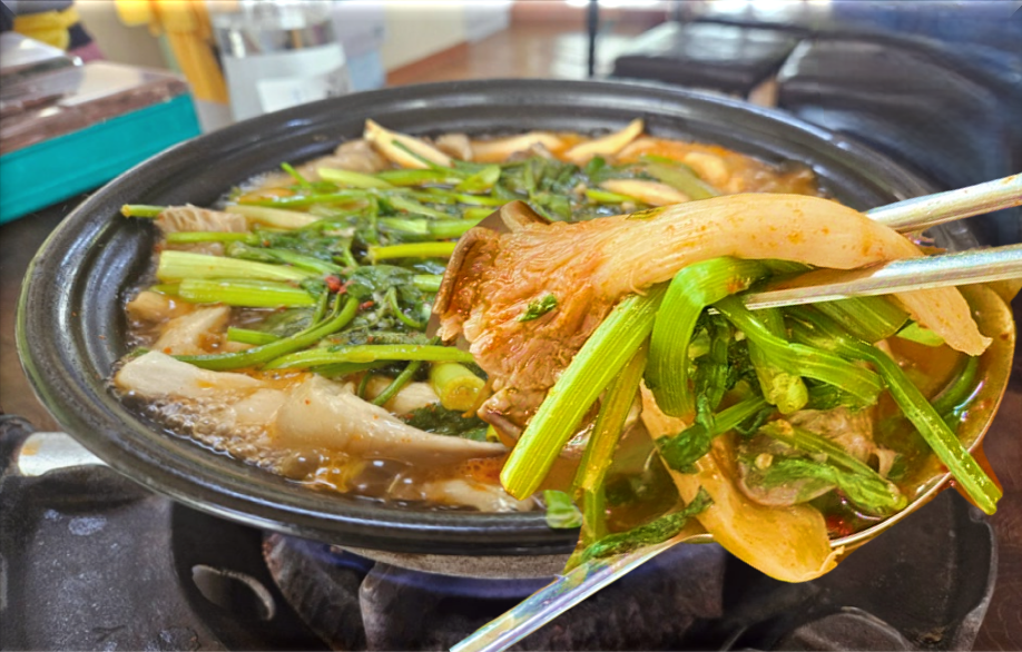 버섯매운탕의 버섯과 미나리 를 함께 건져 올린 모습