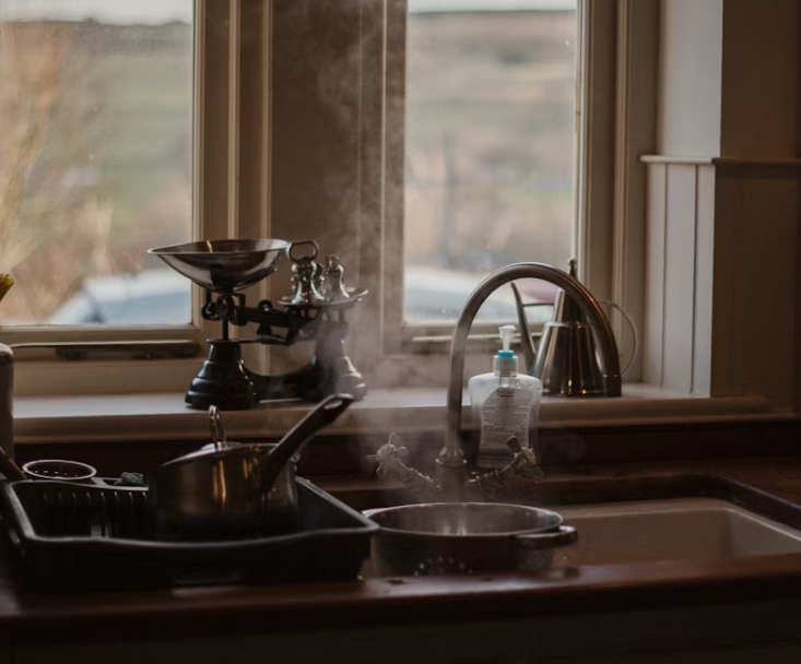 겨울철 주방 싱크대에서 조리 후 발생한 수증기와 습기가 남아 있는 모습