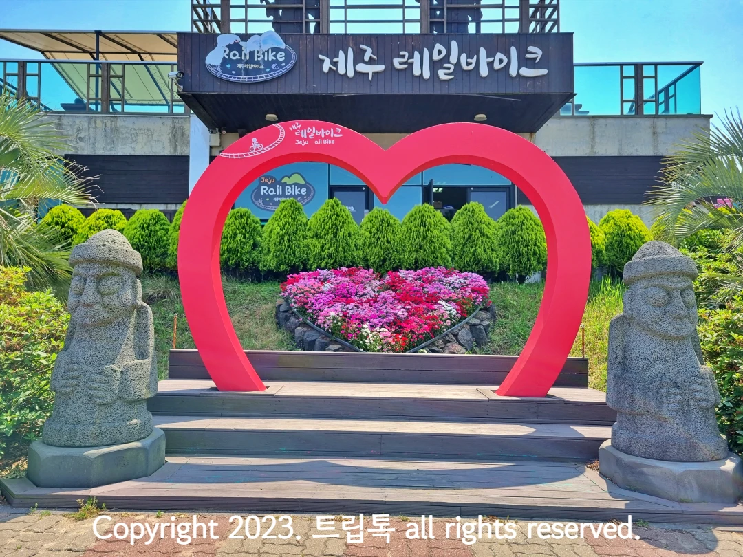 제주레일바이크 건물과 커다란 하트와 돌하르방이 보인다