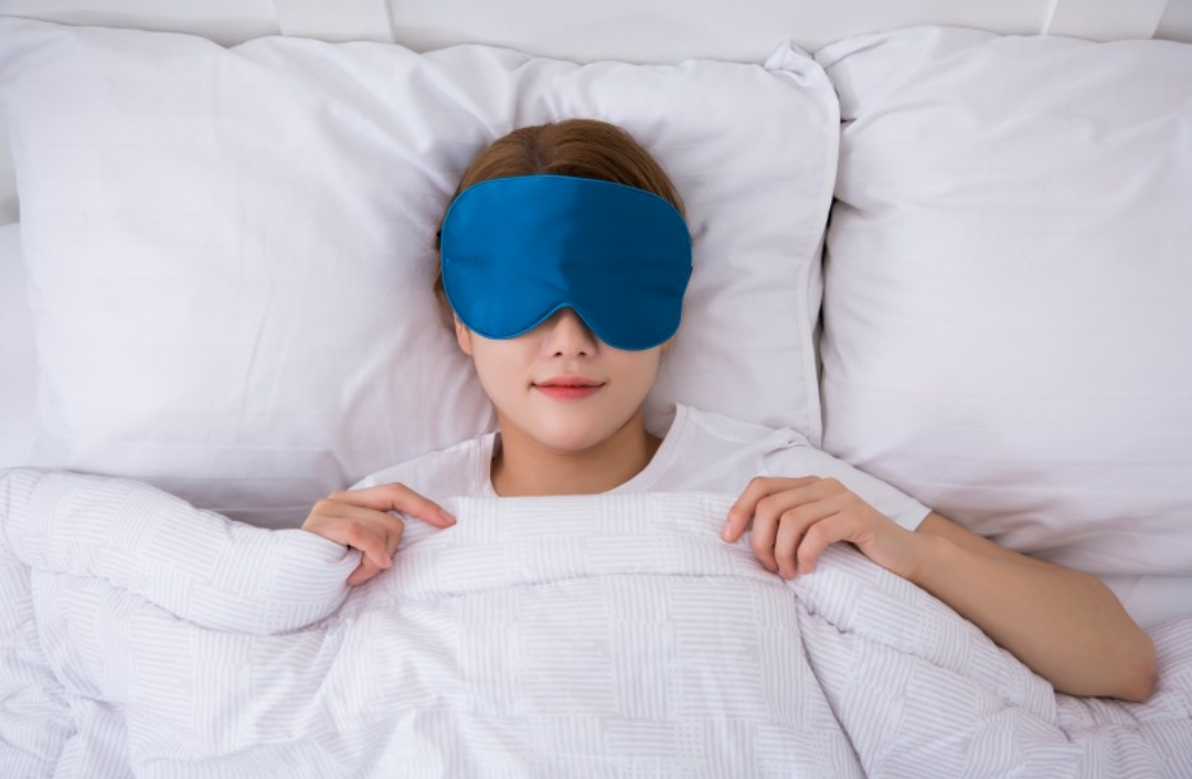 한 여성이 안대를 하고 숙면을 취하고 있다.