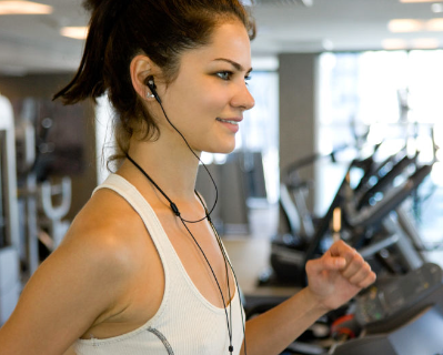 이어폰을 끼고 런닝머신을 하고 있는 여자