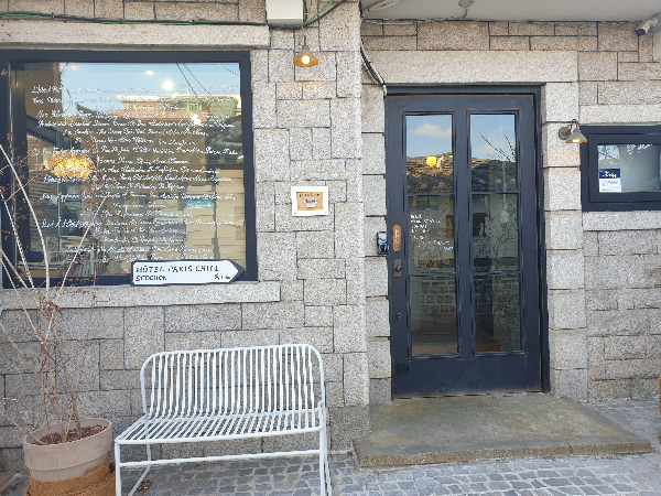 외장을 돌로 쌓은 편집샵. 앞에 흰색 철제 벤치가 느낌있다.