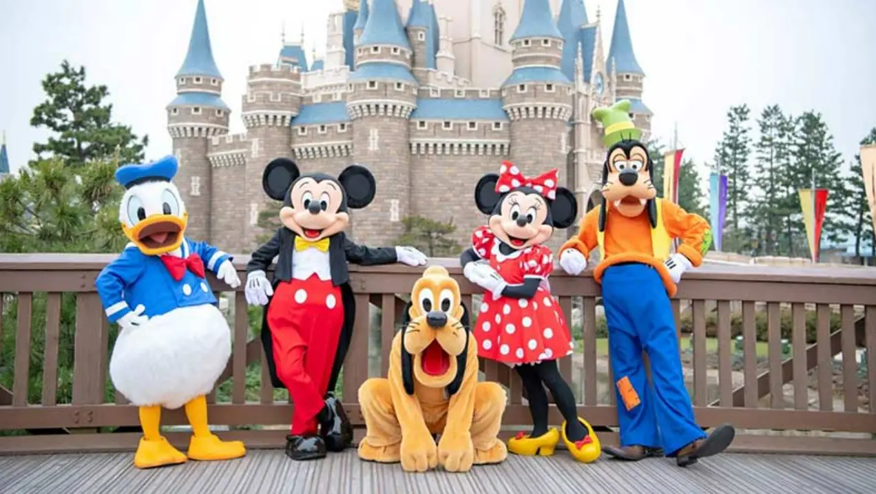 디즈니랜드-뒤쪽-배경-벽돌성-앞-다리에서-포즈를-취하는-디즈니-대표-캐릭터들