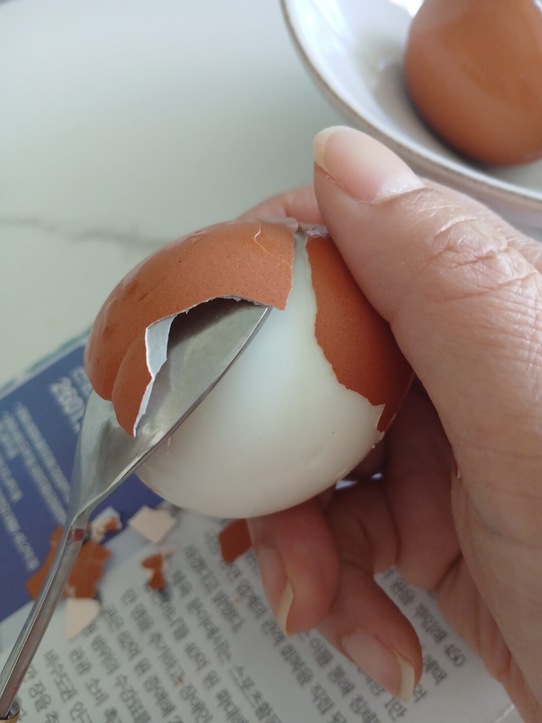 껍질과 계란 사이에 숟가락을 넣어 돌리면 잘 까집니다.