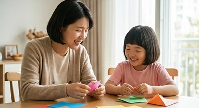 엄마와 딸이 함께 간단한 종이접기를 하며 웃는 모습