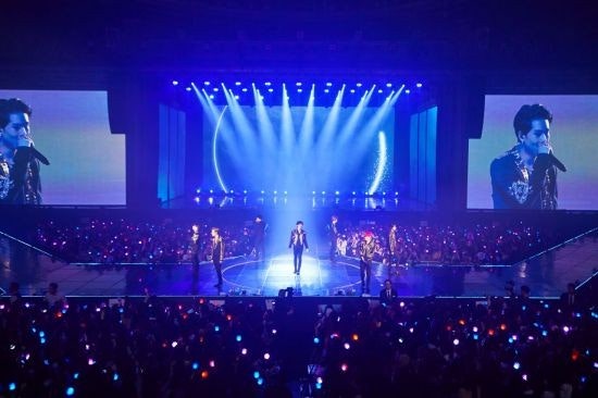 몬스타엑스 멤버들이 무대 위에서 강렬한 파란색 조명 아래 파워풀한 퍼포먼스를 펼치는 모습. 팬들과 소통하는 에너지가 느껴진다.