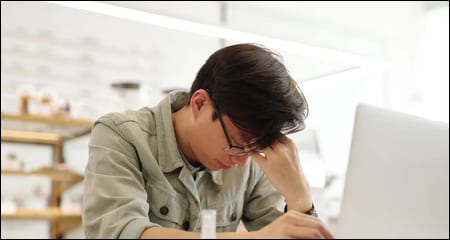 두통으로 머리를 만지고 있는 남성