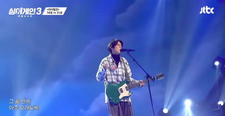 싱어게인3-
체크무늬 셔츠에 검정색 폴로티를 입고 검정색 바지를 입으채 초록색 전기기타를 치며 스탠딩마이크 앞에서 눈을 감고 노래하는 58호