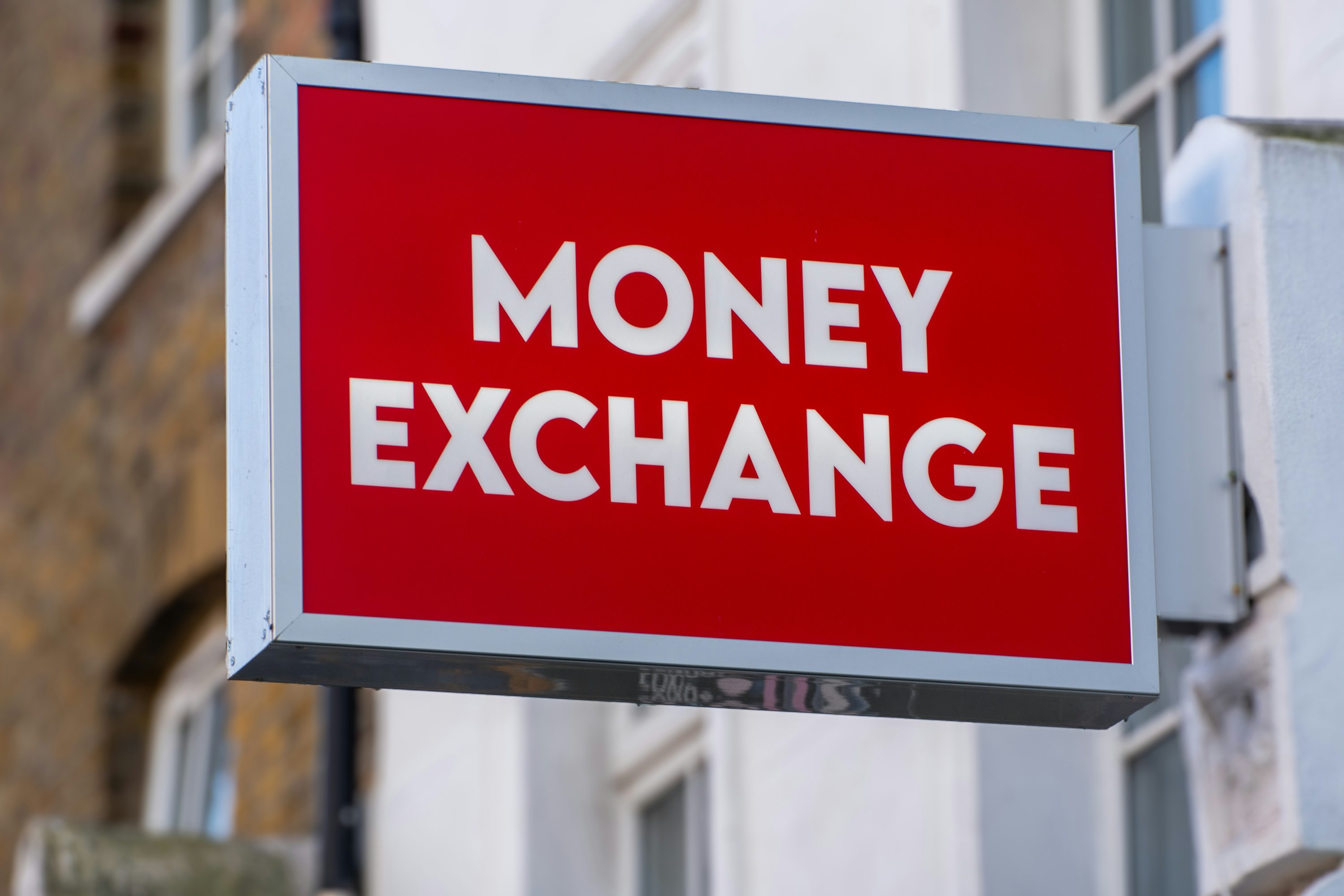 거리의 건물 외벽에 설치된 빨간색 'MONEY EXCHANGE' 환전소 간판 모습
