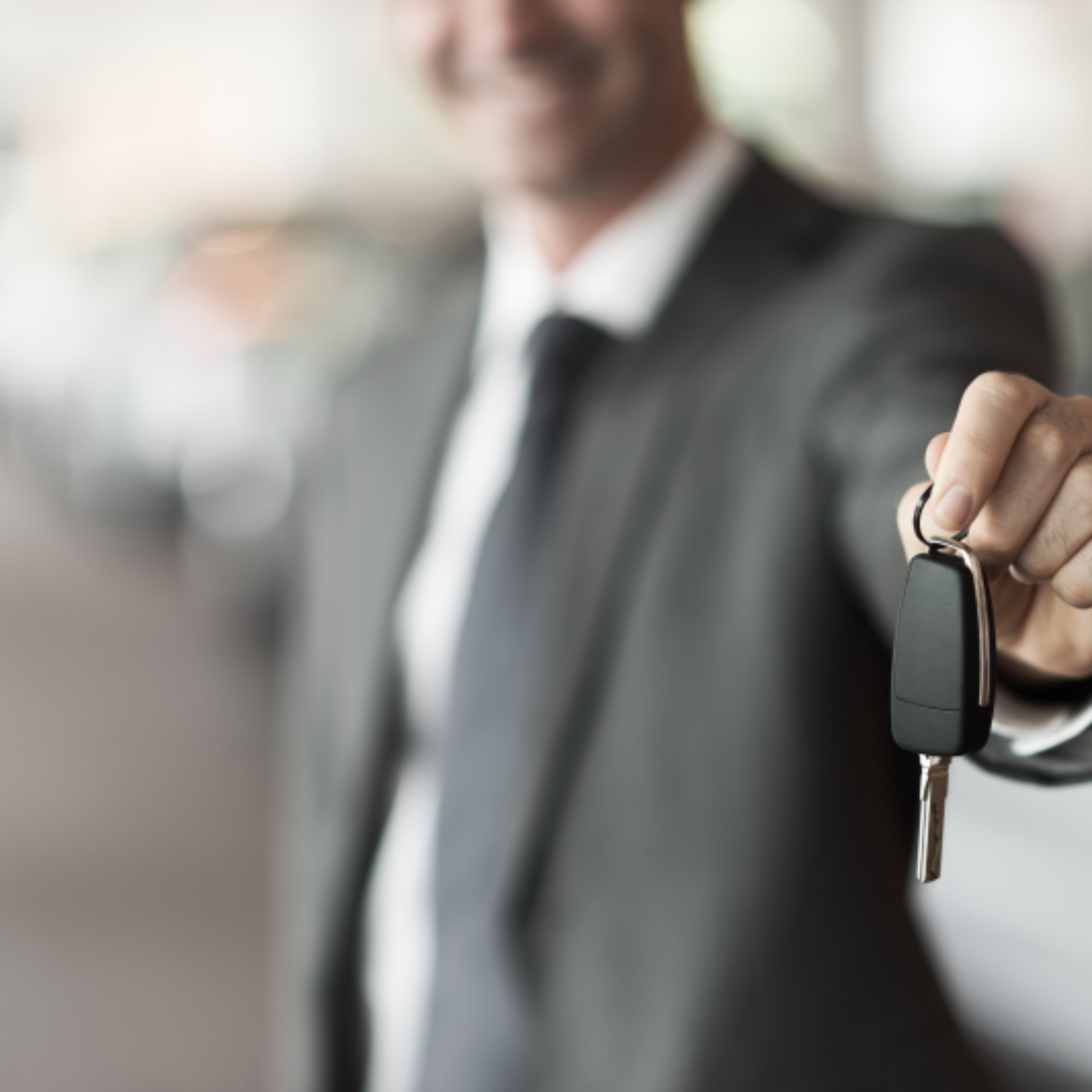 차키를 건네는 검은 정장의 남성