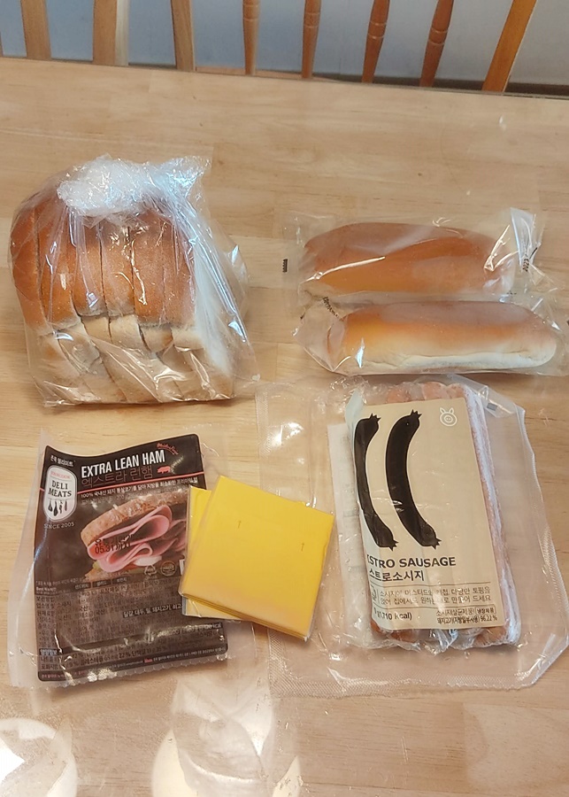 식탁에놓여 있는 식빵 샌드위치용햄 핫도그번 소시지 치즈