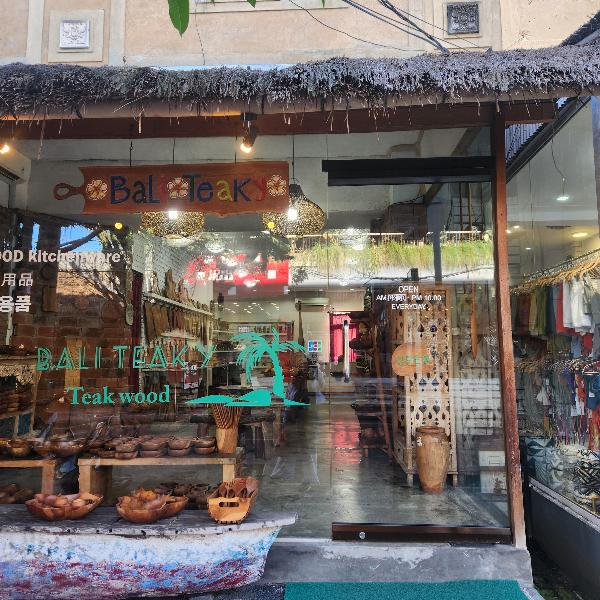 매장 앞. 간판에는 Bali Teaky라고 쓰여있다. 우드 재질의 간판. 윈도우에는 가게 이름이 프린팅되어 있고 매장 안 주방 용품들이 보인다.