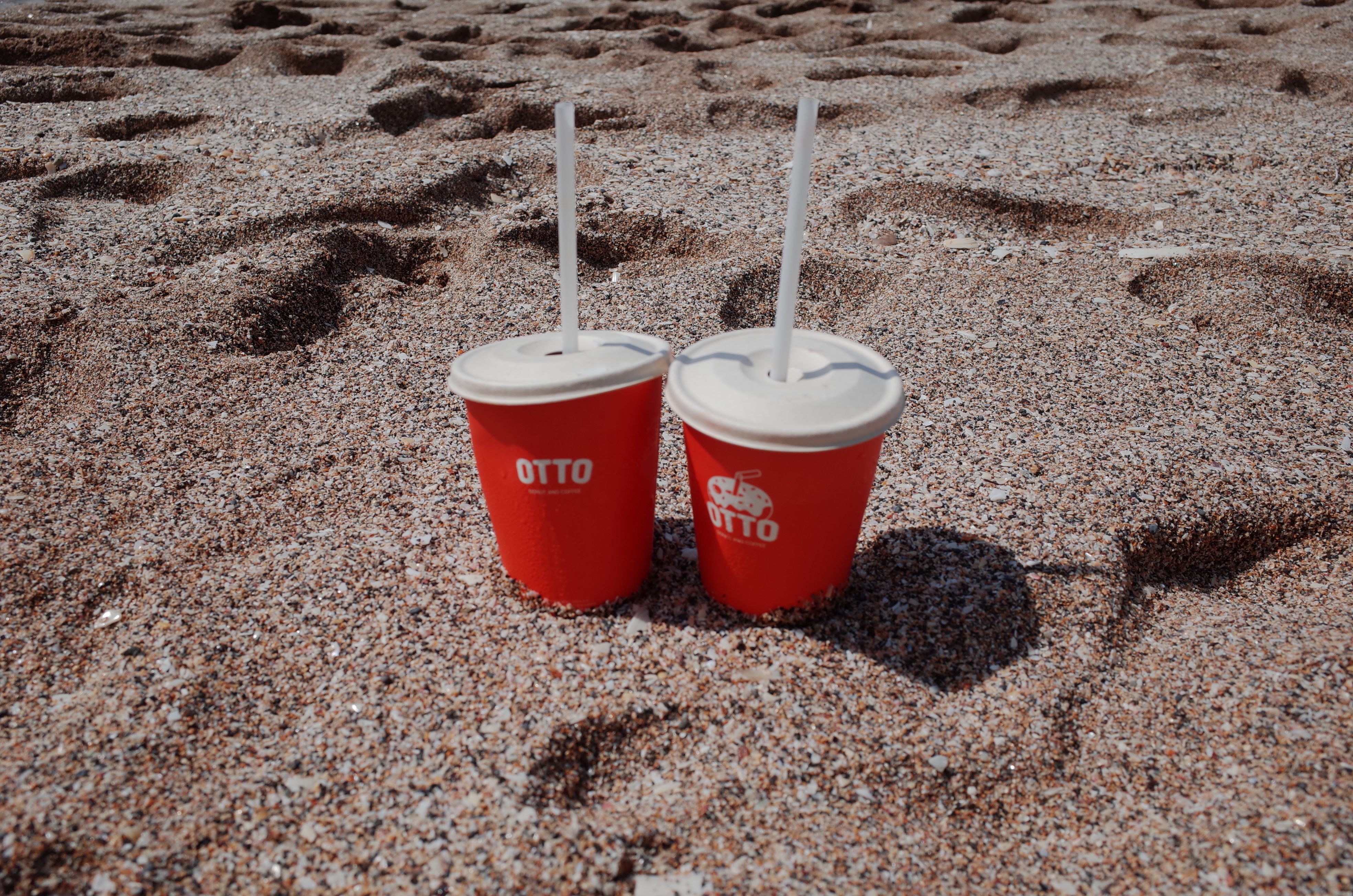 해변_모래에_세워_둔_오또도넛_커피_두잔