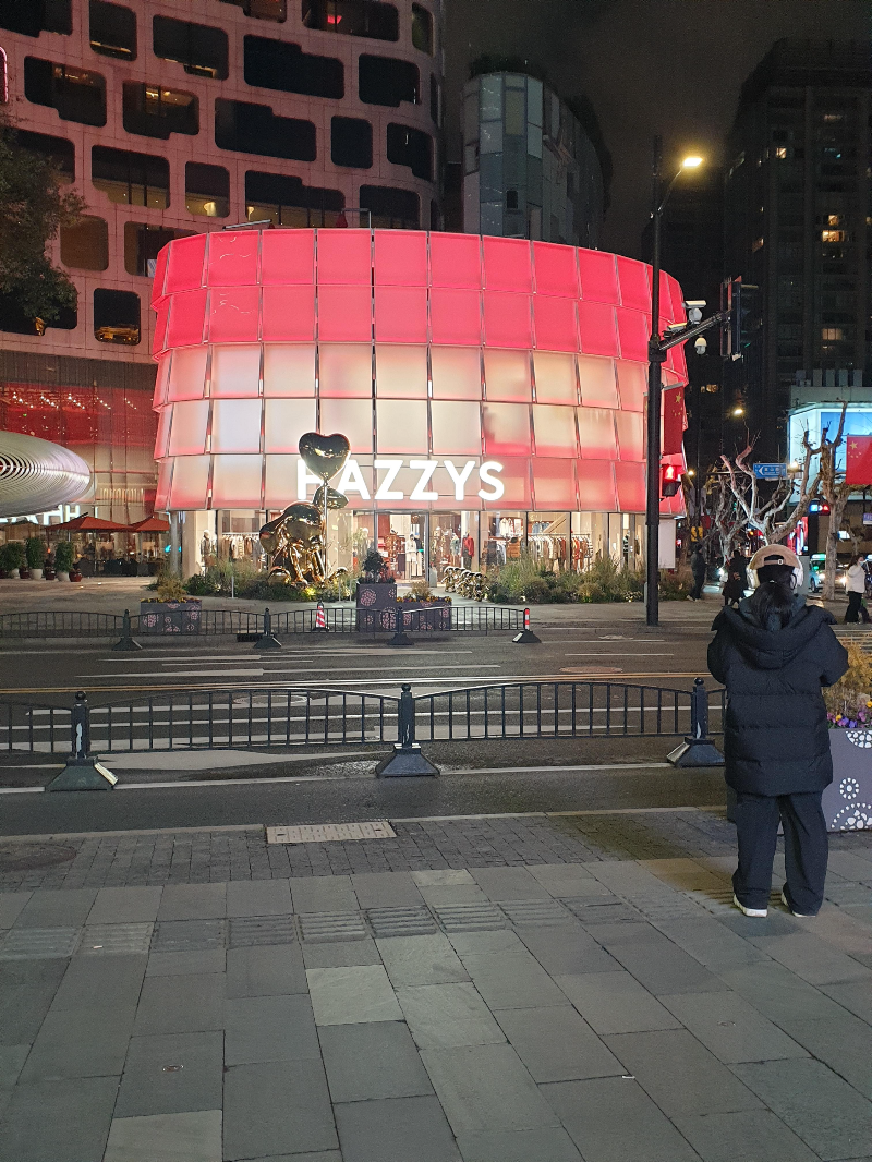 핑크빛 조명으로 꾸며진 hazzys 건물. 명품 브랜드 사이에 있다.