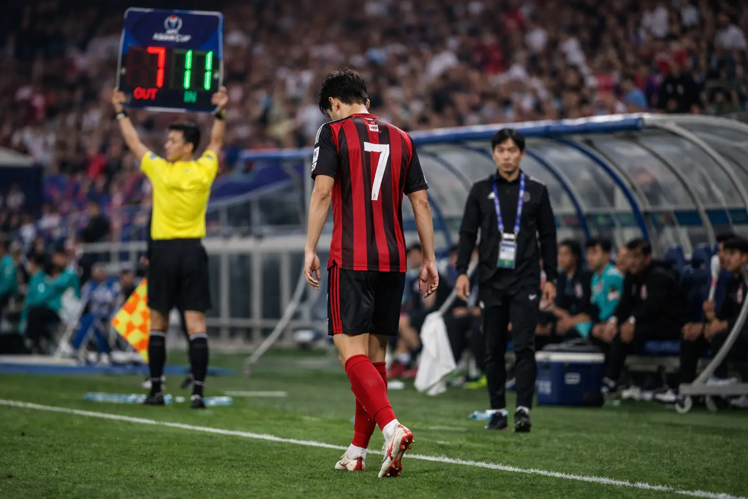 고개를 숙이고 경기장을 나가는 축구 선수 뒷모습