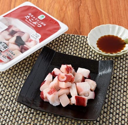 데친 문어가 검은 접시위에 올려져 있다.