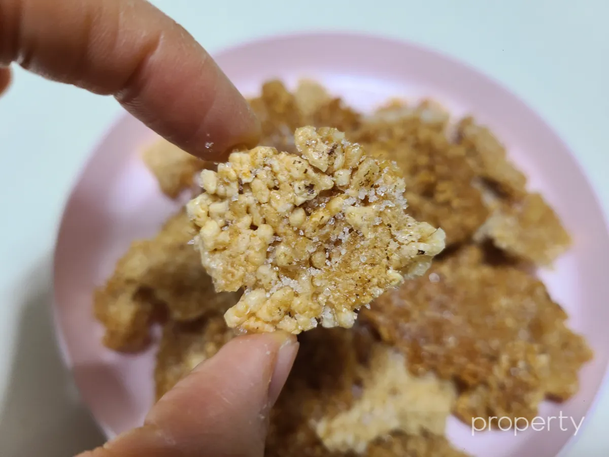 손가락으로-들고있는-설탕이-묻혀진-누룽지튀김과자-한조각