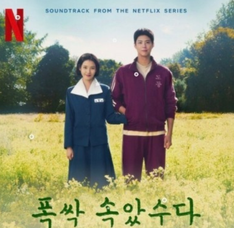 주인공이 맞잡은 두 손을 남자 주인공 잠바 주머니에 넣고 유채 꽃밭에 서 있어요