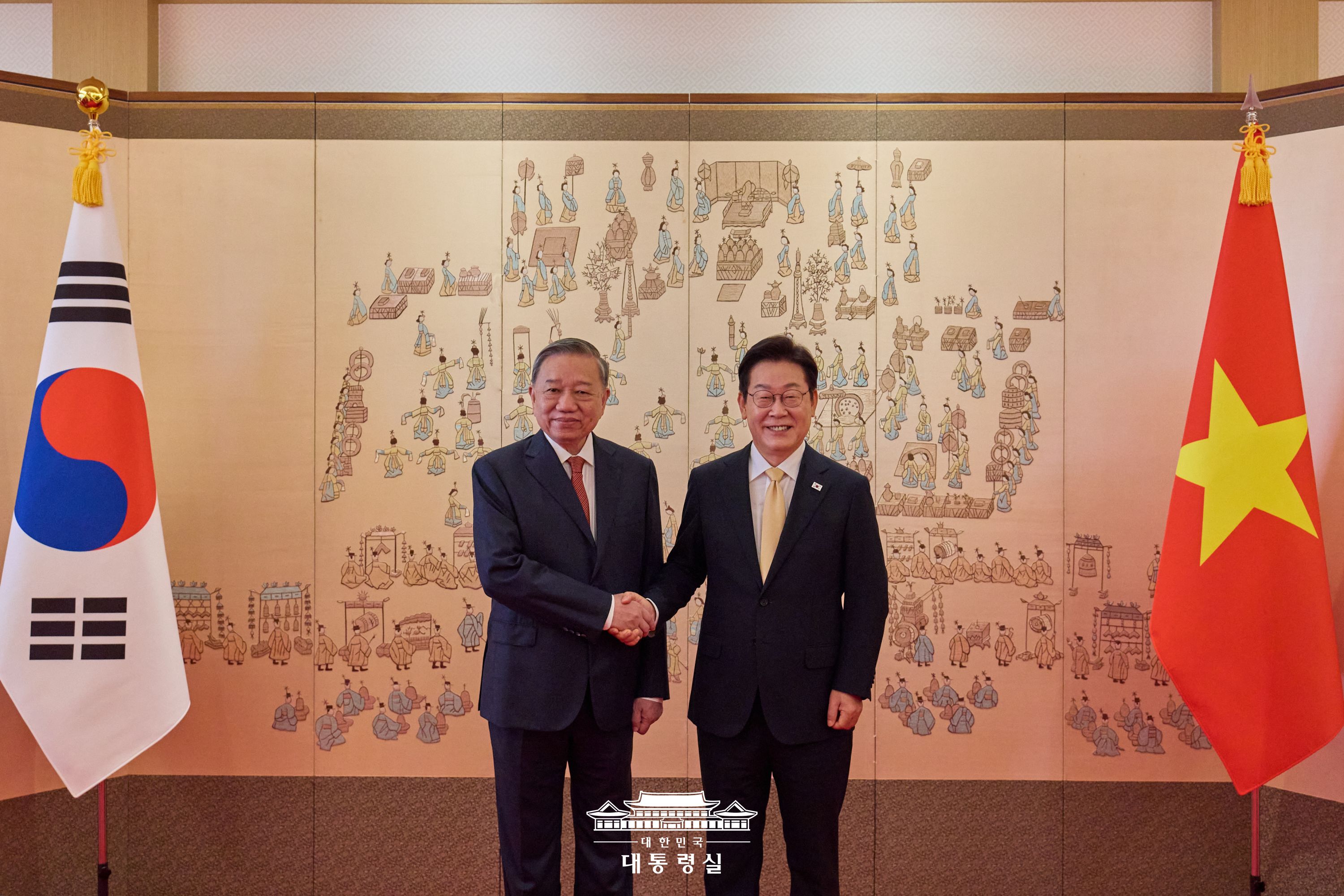 대한민국 대통령실 제공 &ndash; 2025년 8월 한-베트남 정상회담에서 이재명 대한민국 대통령과 또 럼 베트남 공산당 서기장이 서울 청와대 영빈관에서 악수하고 있는 장면. 양국 국기와 전통 병풍이 배경으로 배치됨.