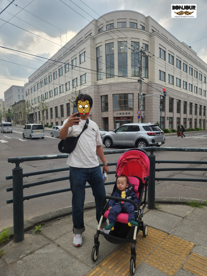 우체국 앞에서 기념 사진 찍는 부자의 모습