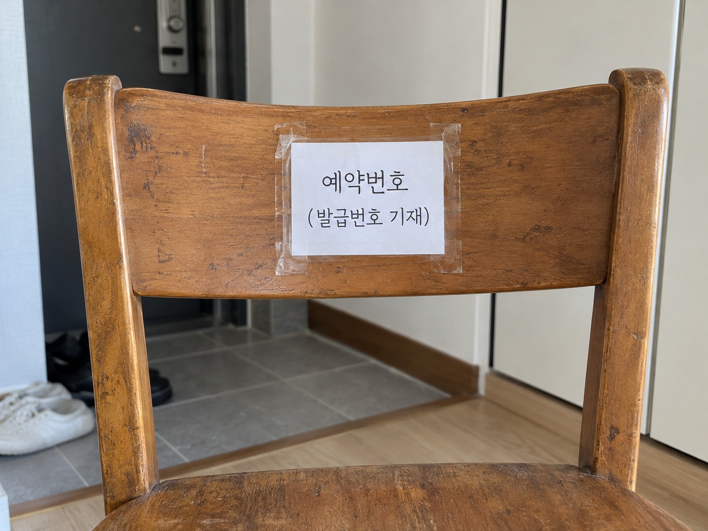 의자 등받이에 예약번호 종이를 고정한 예시