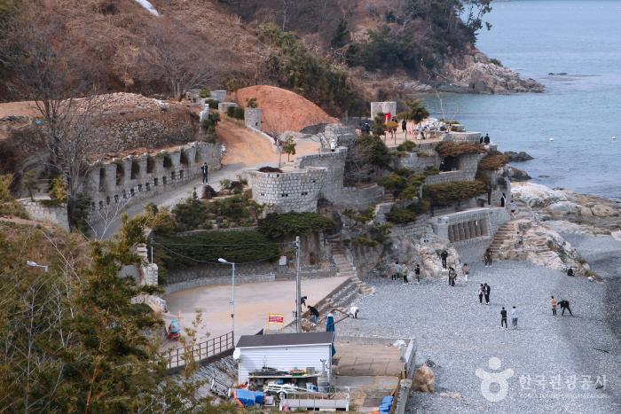 바다옆에 성이있고 해변에는 사람들이 있다.