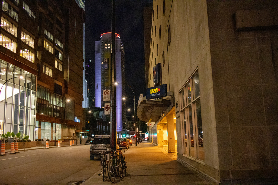 오른쪽에 VIA라고 적혀있는 비아레일의 역 입구가 보인다. 사이에 도로가 있고&amp;#44; 왼쪽에는 유리로 된 통창 건물이 불이 환하게 켜진 채로 있다. 
