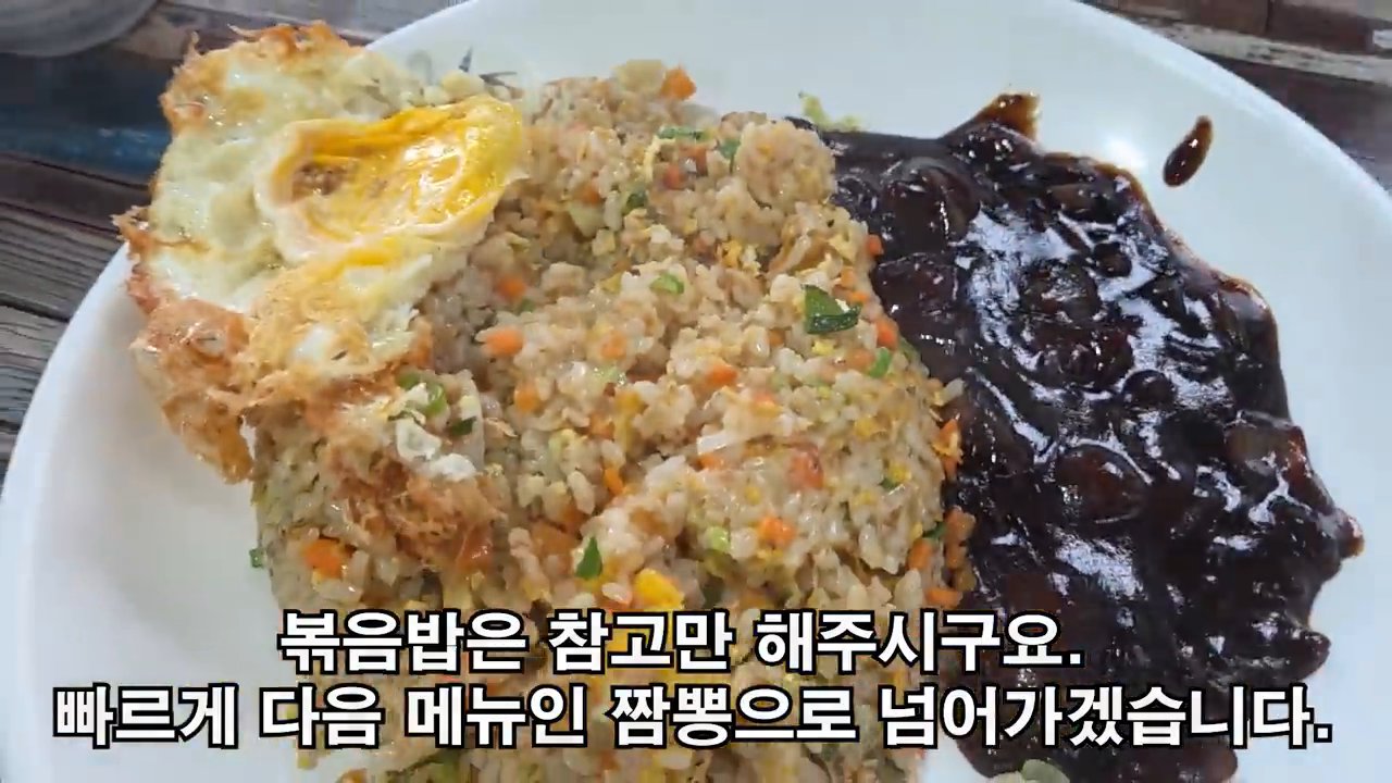 볶음밥에 계란후라이와 짜장 소스를 곁들여 줘요.