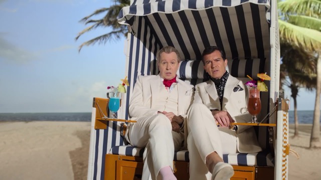 해변에서 두 남자가 의자에 나란히 앉아있는 사진